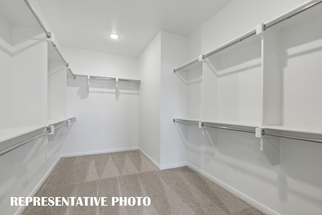 spacious closet featuring light carpet