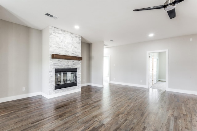 unfurnished living room with a fireplace, ceiling fan, and dark hardwood / wood-style flooring