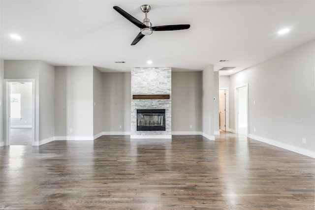 unfurnished living room with dark hardwood / wood-style flooring, ceiling fan, and a fireplace