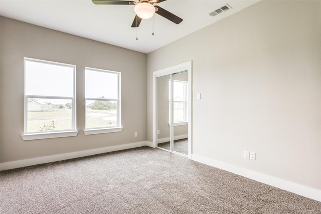 spare room with carpet floors, ceiling fan, and a healthy amount of sunlight