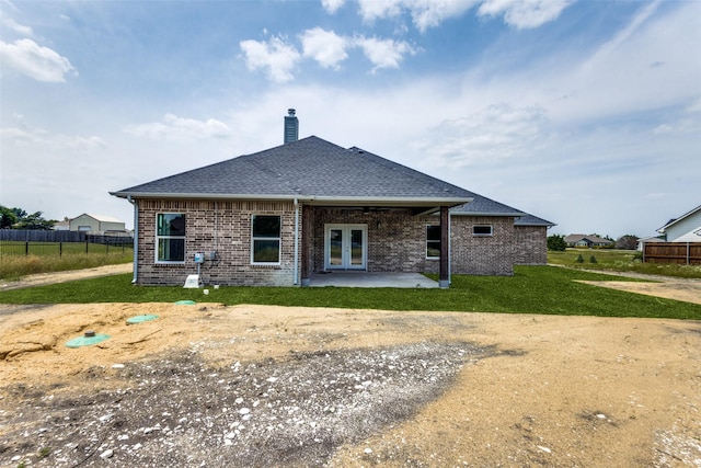 rear view of property featuring a patio area and a lawn