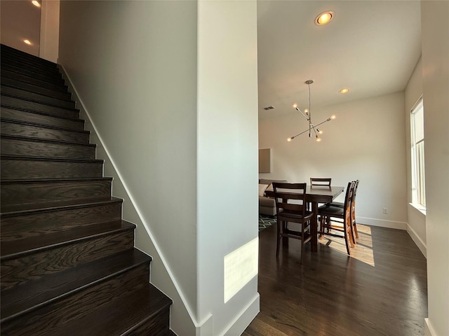 stairs featuring a chandelier and wood-type flooring