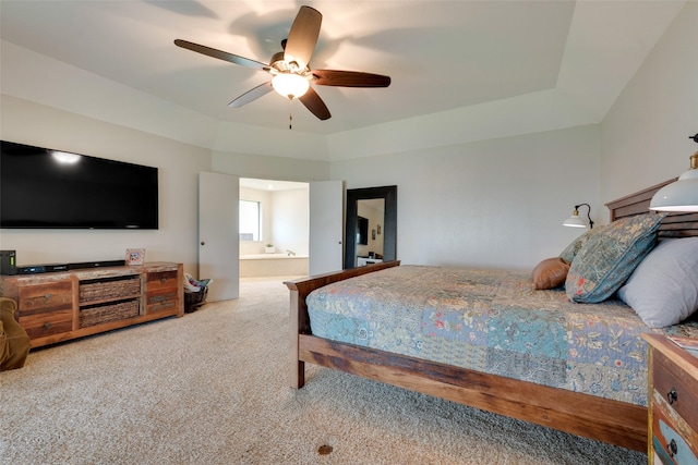 bedroom featuring carpet, a raised ceiling, ceiling fan, and ensuite bath