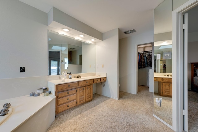 bathroom with visible vents, a spacious closet, and vanity