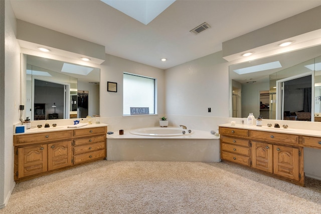 full bathroom with a bath, two vanities, a sink, and visible vents