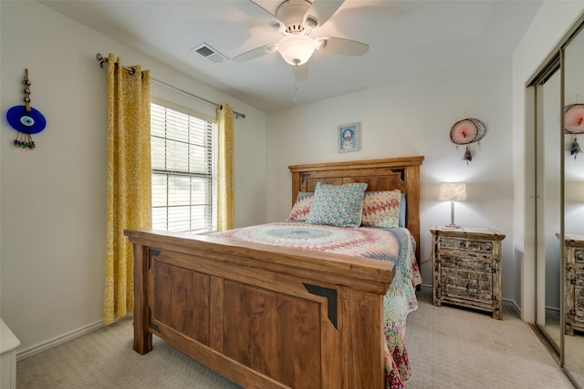 bedroom featuring light carpet, visible vents, baseboards, a ceiling fan, and a closet