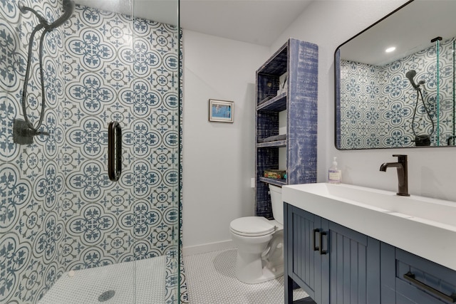 bathroom with baseboards, tiled shower, toilet, tile patterned floors, and vanity