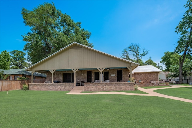 view of front of home featuring covered porch, brick siding, a front yard, and fence