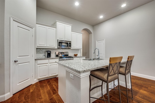 kitchen featuring an island with sink, white cabinetry, appliances with stainless steel finishes, and a sink