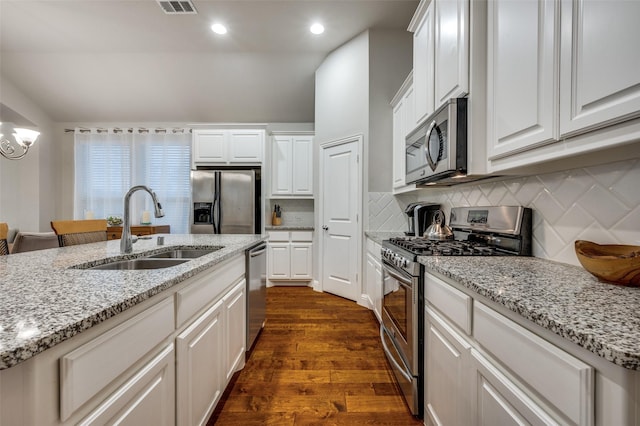 kitchen featuring stainless steel appliances, white cabinetry, a sink, and dark wood-style floors