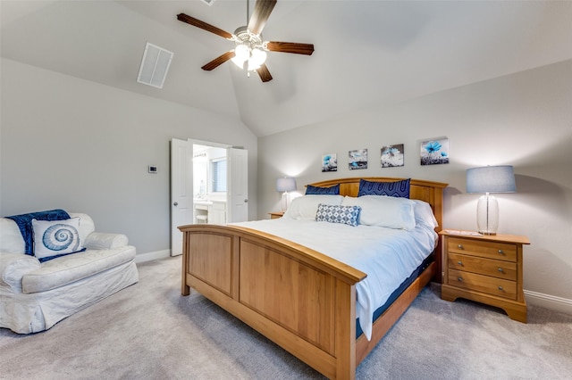 bedroom with lofted ceiling, ensuite bathroom, visible vents, and light colored carpet