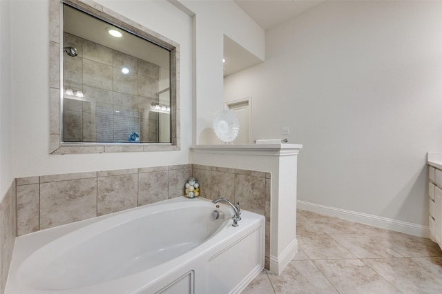 bathroom featuring a shower stall, vanity, a bath, baseboards, and tile patterned floors