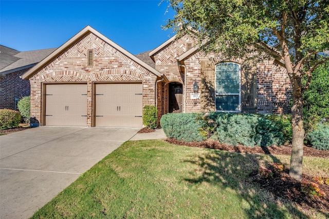 french country style house with a garage, driveway, brick siding, and a front yard