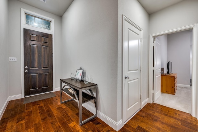 entryway with dark wood-style flooring and baseboards