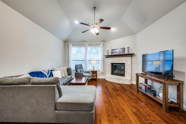 living area featuring dark wood-type flooring, a fireplace, a ceiling fan, baseboards, and vaulted ceiling