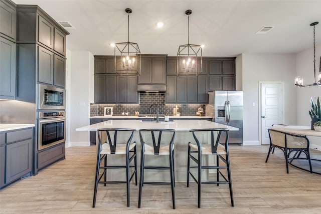 kitchen featuring stainless steel appliances, backsplash, light countertops, and visible vents