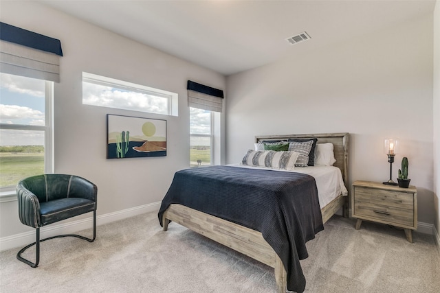 bedroom with light carpet, visible vents, and baseboards