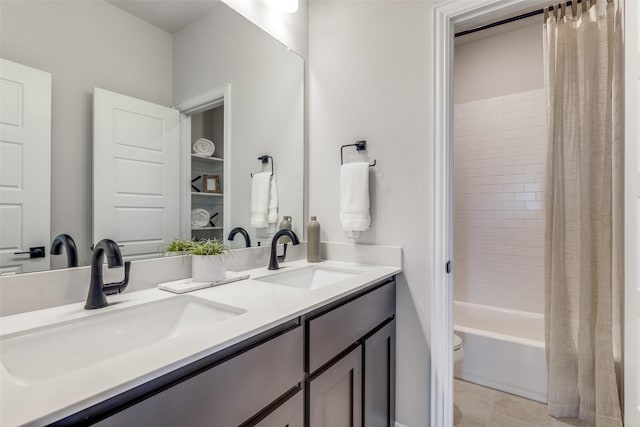 bathroom featuring double vanity, shower / bath combination with curtain, toilet, and a sink