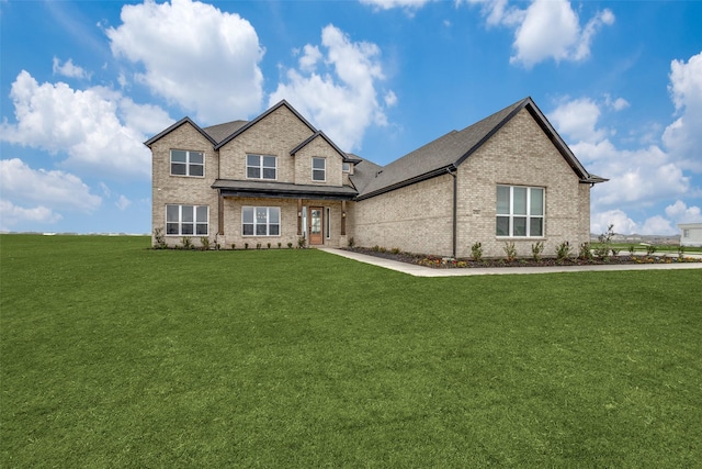 view of front facade with brick siding and a front lawn