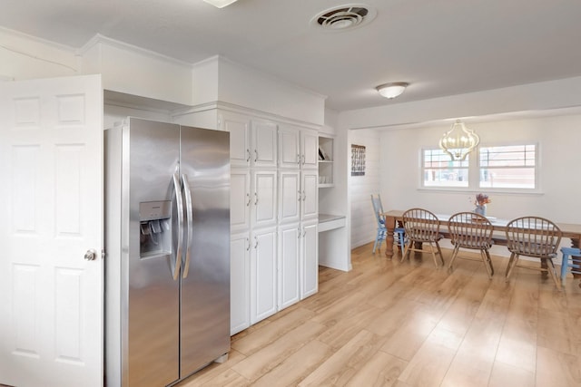 kitchen featuring a chandelier, white cabinetry, stainless steel fridge with ice dispenser, light hardwood / wood-style floors, and hanging light fixtures