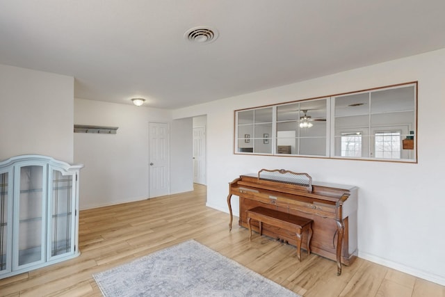 living area featuring ceiling fan and light hardwood / wood-style floors