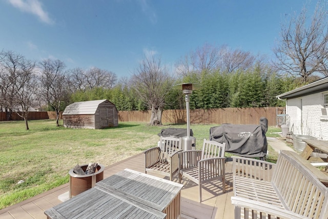 wooden terrace featuring a lawn and a storage shed