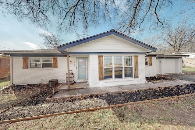 back of house with a garage, a patio, and central air condition unit