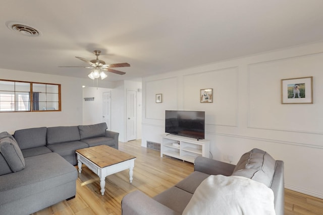 living room with light wood-type flooring and ceiling fan