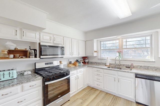 kitchen featuring sink, light stone countertops, white cabinetry, and stainless steel appliances