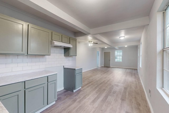 kitchen featuring light wood-type flooring, ceiling fan, beamed ceiling, and tasteful backsplash