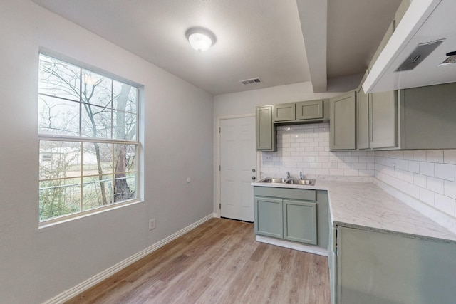 505 Oak St, Commerce, TX 75428 - kitchen with backsplash, healthy amount of natural light, light wood-style flooring, and beam ceiling