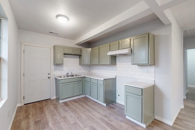 kitchen with light hardwood / wood-style flooring, sink, and decorative backsplash