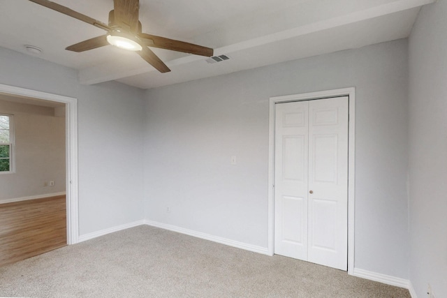 unfurnished bedroom featuring light carpet, ceiling fan, and a closet