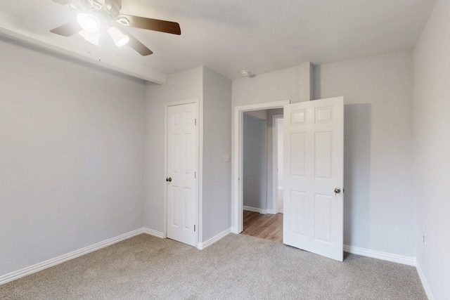 unfurnished bedroom featuring light colored carpet and ceiling fan