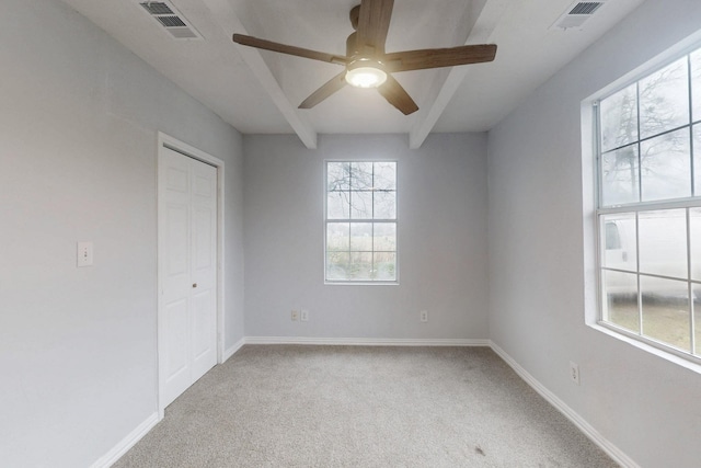 carpeted empty room featuring ceiling fan and beam ceiling