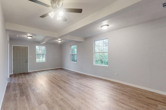 empty room with ceiling fan, beamed ceiling, and light wood-type flooring