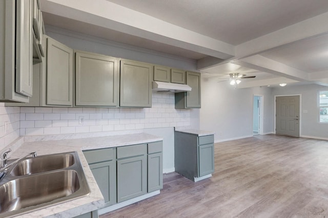 kitchen with light hardwood / wood-style flooring, sink, ceiling fan, beamed ceiling, and decorative backsplash