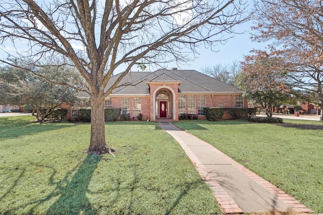 view of front of property featuring brick siding and a front yard