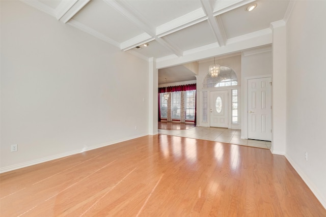 entryway featuring a chandelier, coffered ceiling, baseboards, and wood finished floors