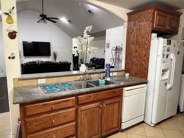 kitchen with white appliances, lofted ceiling, sink, and dark stone counters