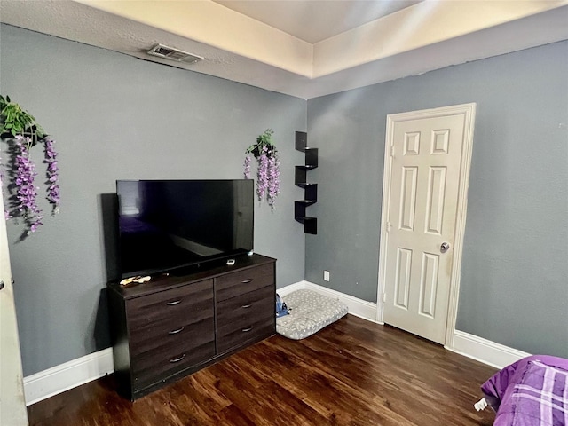 bedroom with dark hardwood / wood-style floors