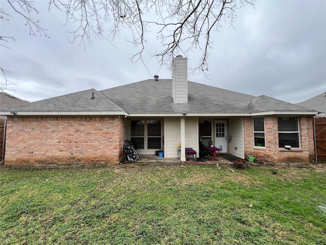 back of house with a lawn and a patio