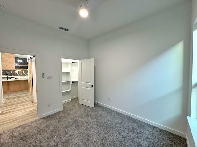 unfurnished bedroom featuring carpet, a closet, and a spacious closet