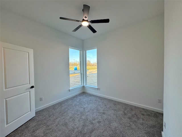 empty room featuring dark carpet and ceiling fan