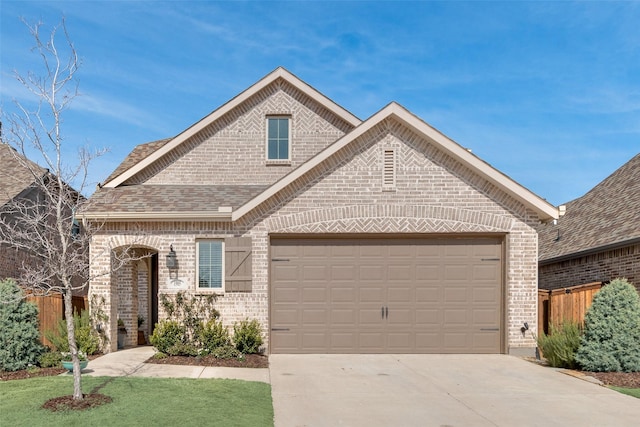 view of front of property with concrete driveway, brick siding, an attached garage, and fence