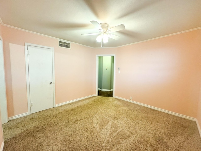 carpeted spare room with crown molding and ceiling fan