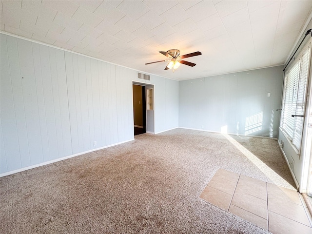 carpeted spare room featuring ceiling fan and ornamental molding