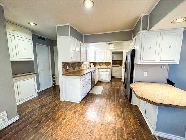 kitchen with appliances with stainless steel finishes, decorative backsplash, sink, white cabinetry, and dark hardwood / wood-style floors