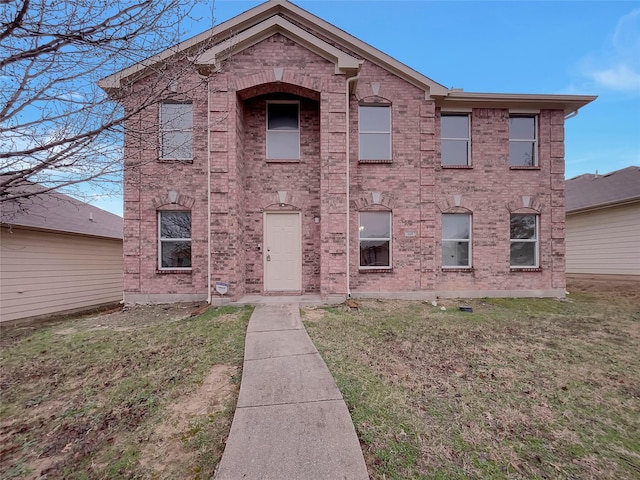 view of front facade with a front yard and brick siding