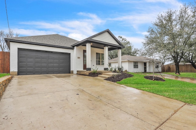 view of front facade featuring a front lawn, a garage, and covered porch